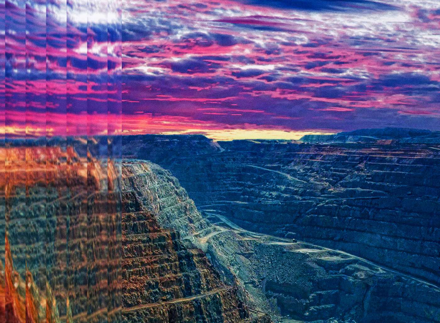 Terraced walls of an open-pit mine at dusk
